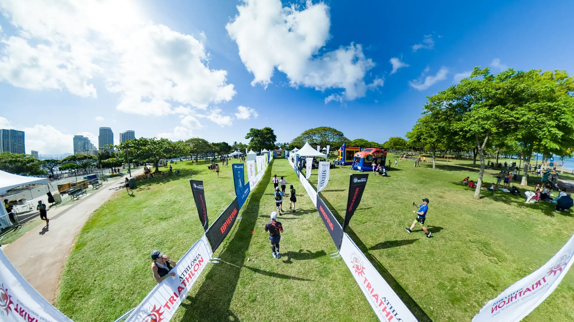 Athletes walking across the grassy race village on event day